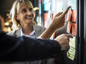 discussing post it notes on whiteboard